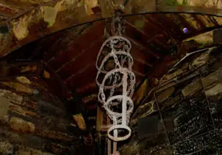 An eerie torture device is hanging from the ceiling in Dark Dungeon Escape game.